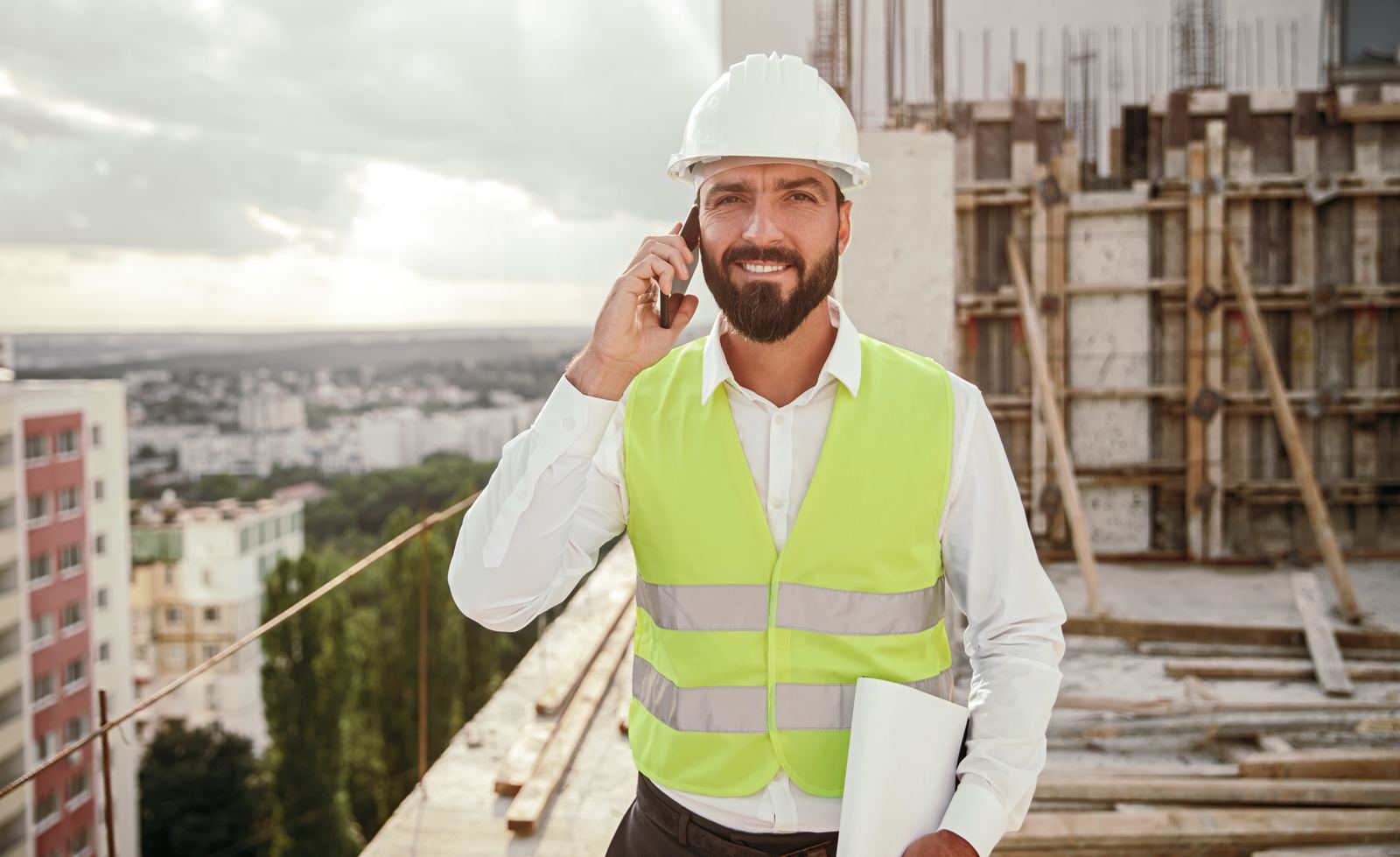 Construction worker answering phone call on site