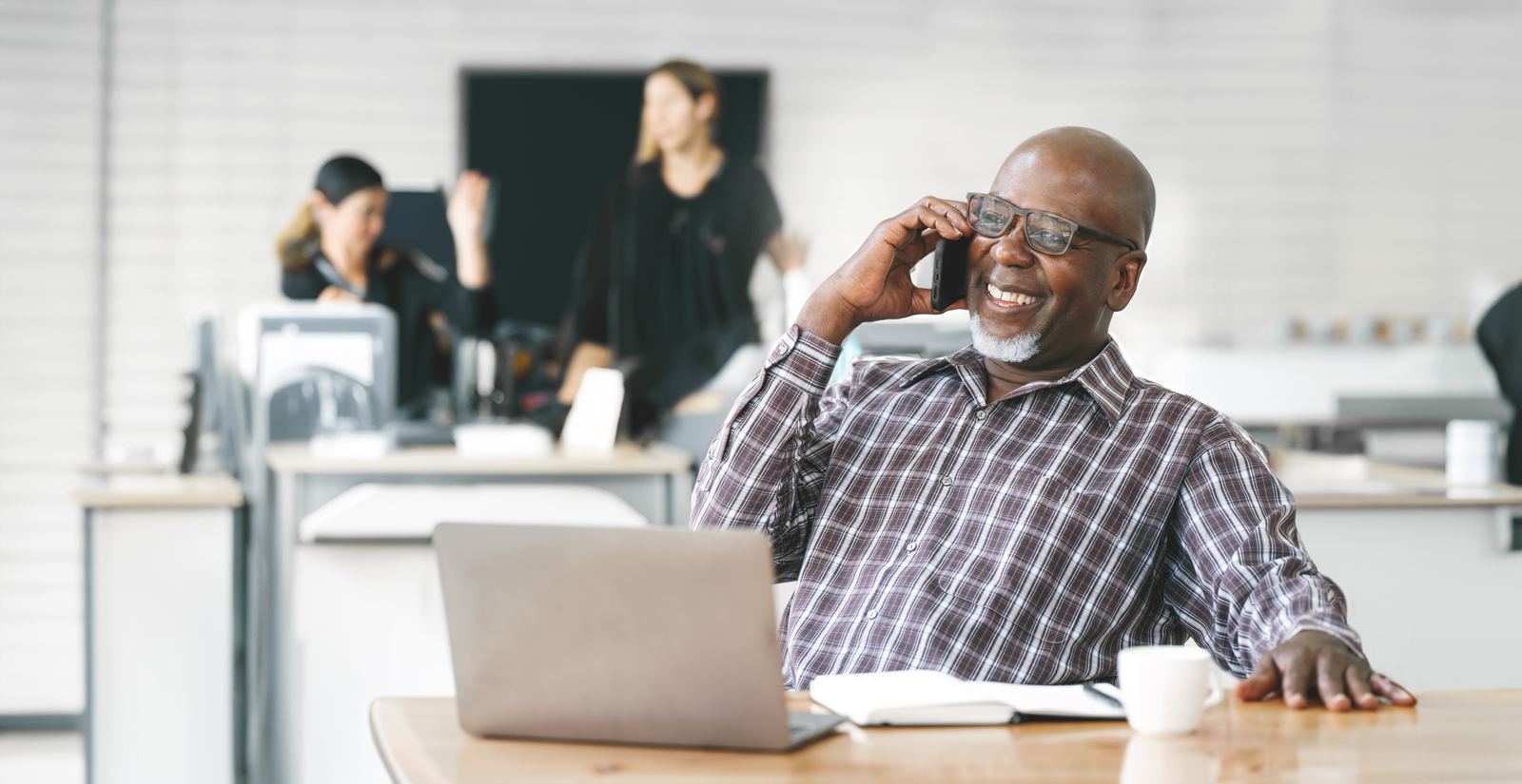 Portrait of happy African American small business owner talking on mobile phone Millennial black male team