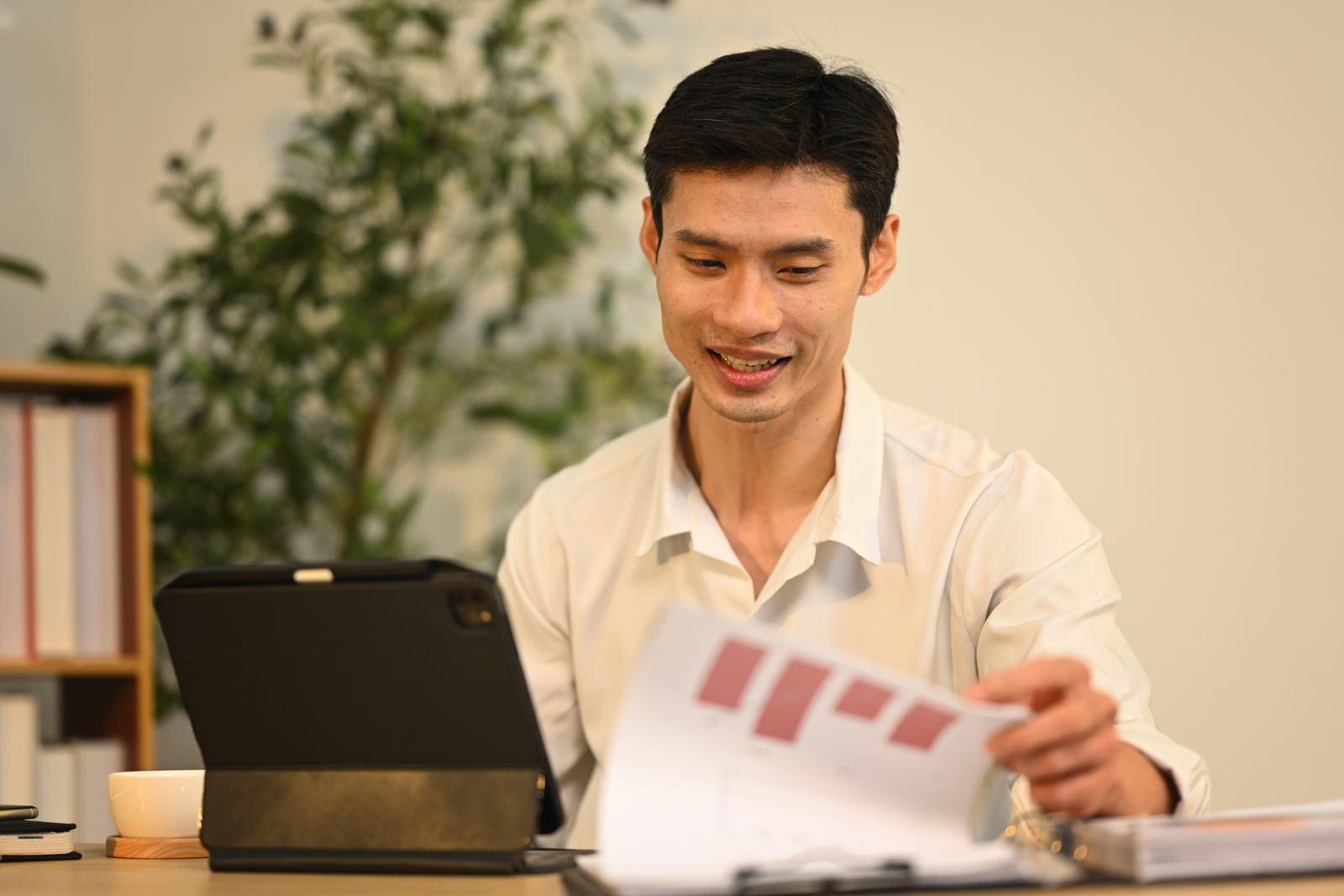 Confident businessman reviewing charts and data at desk