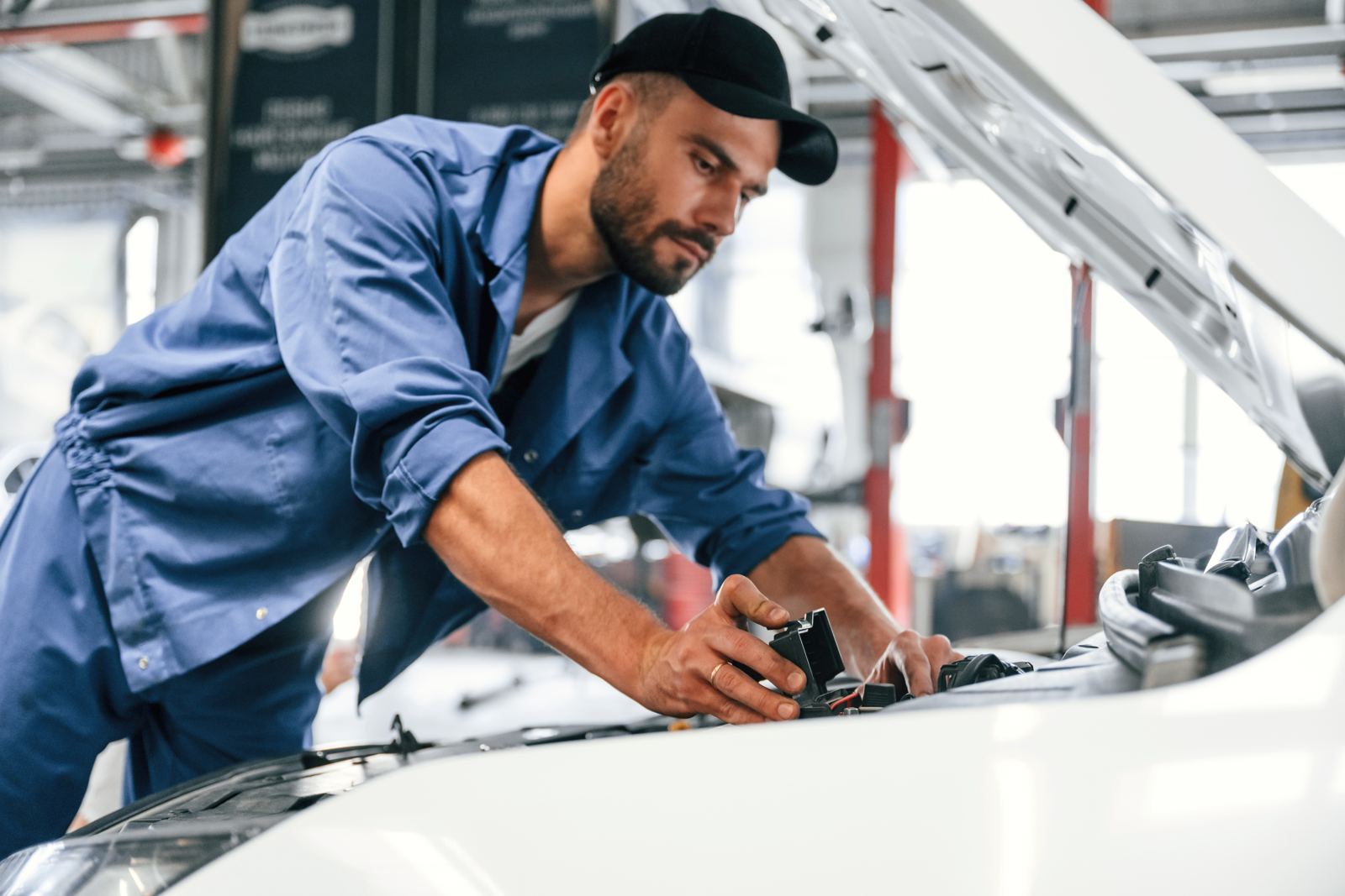Working by repairing the car Hood is opened Auto mechanic is in garage Repair service