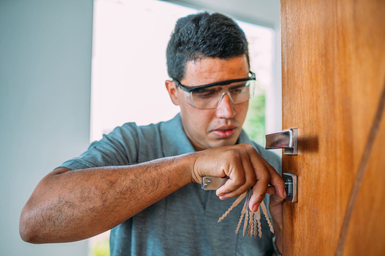 Locksmith opening a door Male hands repair or installing a metal door lock with a screwdriver
